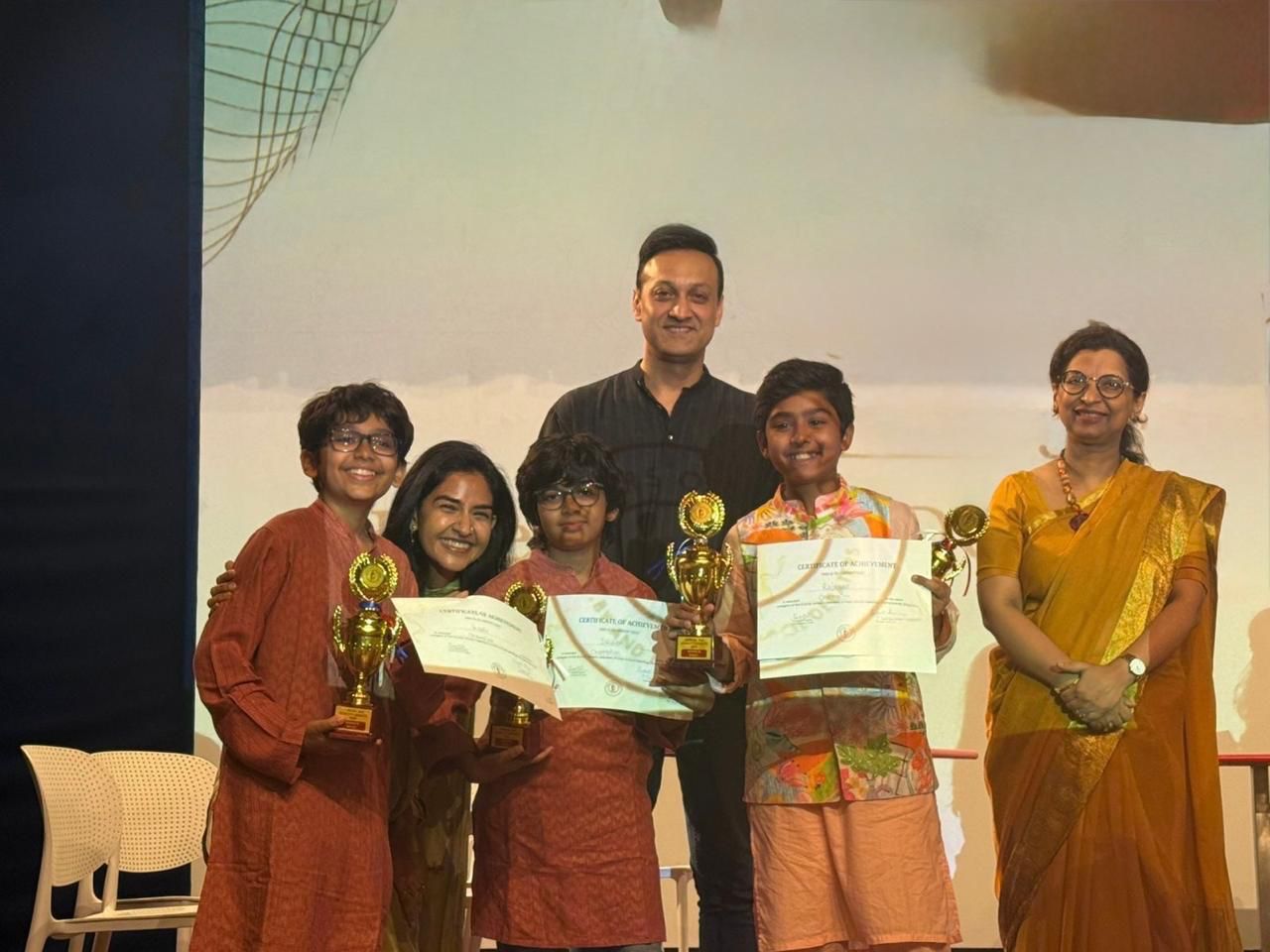Children and adults with trophies and certificates at the Parent and Child Debate, 2024