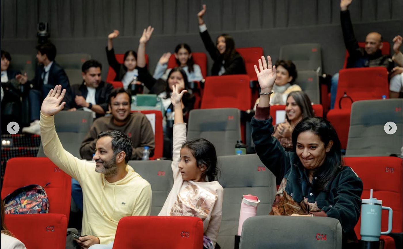 Parents and children raising their hands at the Parent and Child Debate, 2025