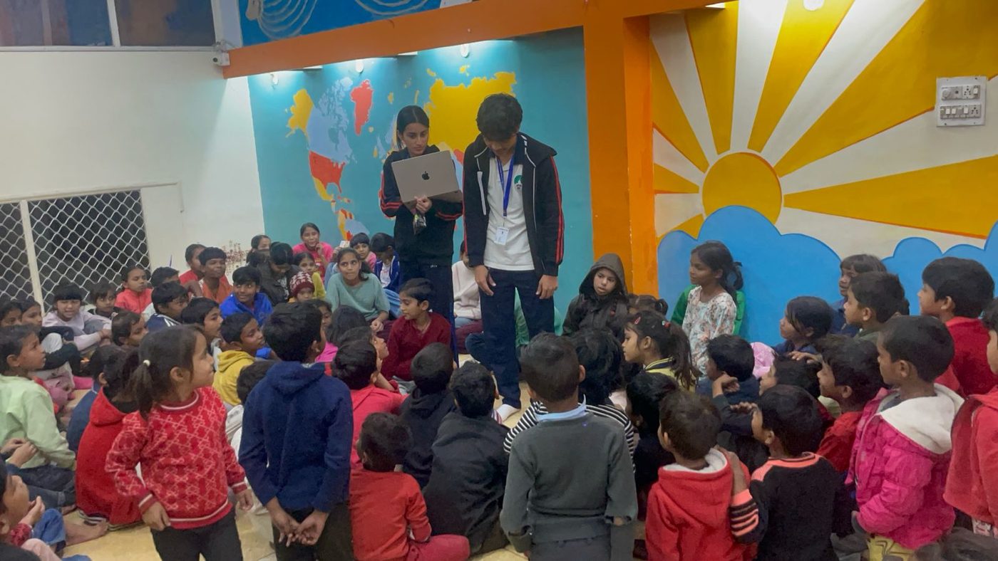 Leading a civic-awareness workshop with a large group of children seated on the floor