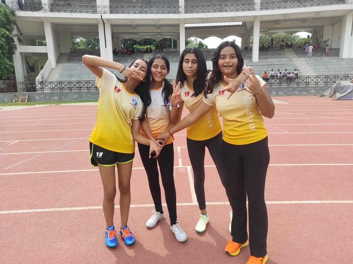Four teammates in yellow team kit on the track