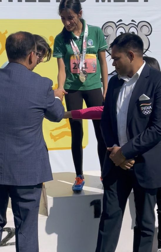 An athlete receiving a medal on the podium from officials
