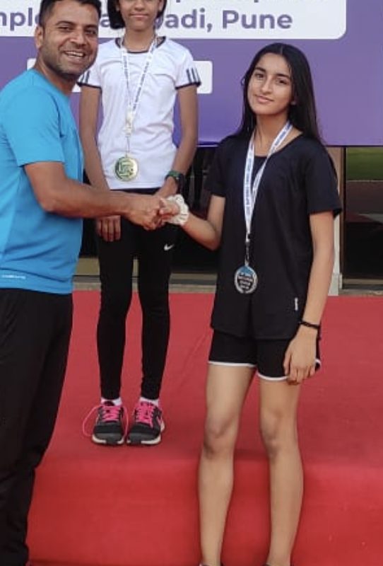 An athlete shaking hands with an official after receiving a silver medal
